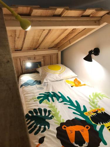 1 dormitorio con 1 cama con colcha de temática tropical en Chambres d'Hôtes La Téouleyre, en Saint-Julien-en-Born