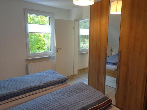 a bedroom with two beds and two windows at Ferienwohnung Dawe in Göttingen