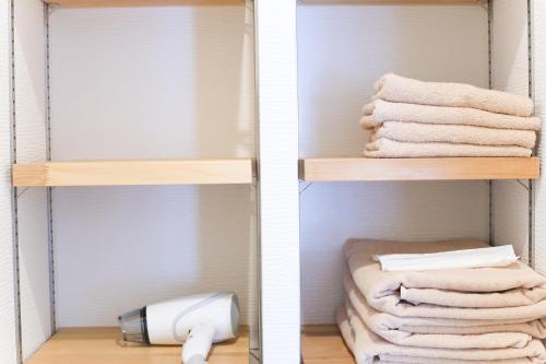two pictures of a bathroom closet with towels at Guest House Re-worth Yabacho1 202 in Nagoya