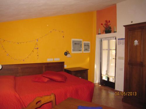 a bedroom with a red bed and a yellow wall at Il Borgo Di Campi in Riomaggiore