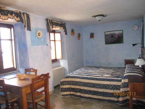 a bedroom with a bed and a table and two windows at Il Borgo Di Campi in Riomaggiore