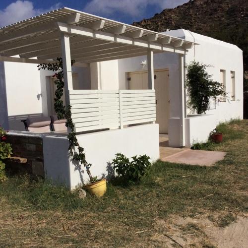 a white house with a pergola at Ostria Village in Mylopotas