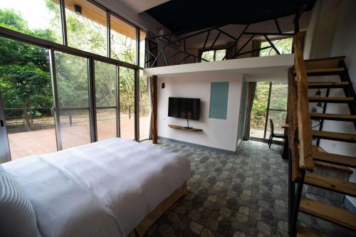 una camera con letto e TV e alcune finestre di Toptai Homestay a Kenting
