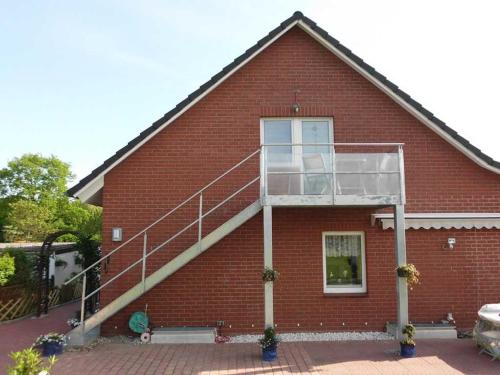 una casa in mattoni rossi con una scala di Ferienwohnung Reins a Neustadt in Holstein