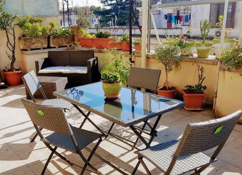 een tafel en stoelen op een patio met potplanten bij Robta's Dream Home in Rome