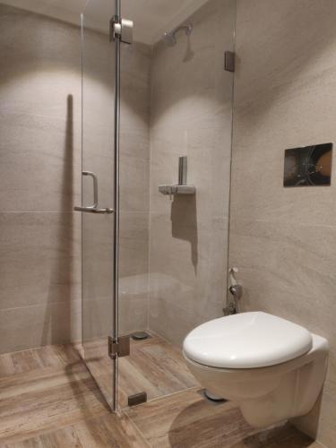 ein Badezimmer mit Toilette und Glasdusche in der Unterkunft Meritas Countryside Resort Lonavala in Lonavla