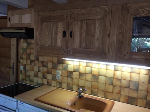 サン・ジェルヴェ・レ・バンにあるChalet Le Paddockのシンクと木製のキャビネットを備えたキッチン