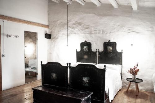 a bedroom with a black bed and a white wall at WUNDERGARTEN Dimora dei Frati in Gratteri