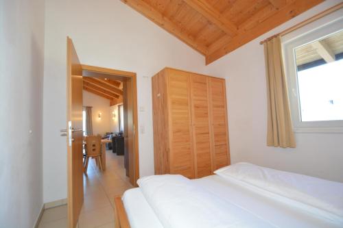 カプルーンにあるApartment Peter in Adler Resort by Z-K-H Rentalsの白いベッドと木製のドアが備わるベッドルーム1室が備わります。