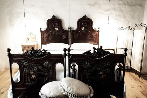 a bedroom with a black and white bed with white pillows at WUNDERGARTEN Dimora dei Frati in Gratteri
