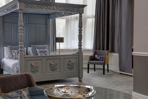 a bedroom with a canopy bed with a coffee table at Walworth Castle Hotel, BW Signature Collection in Darlington