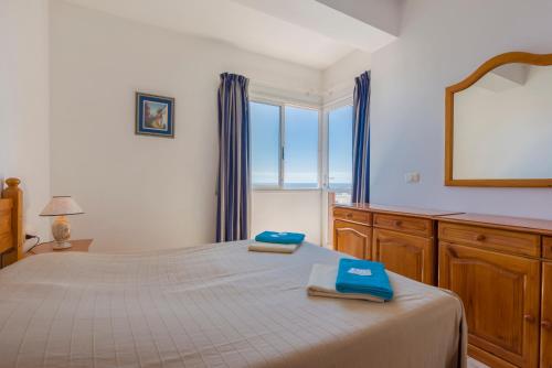 een slaapkamer met een bed met blauwe handdoeken bij Bahia suite in Puerto de Santiago
