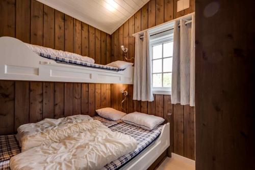 a bedroom with two bunk beds and a window at Bitigrenda G in Beitostøl