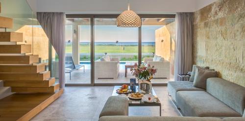 a living room with a couch and a table at Astir Odysseus Kos Resort and Spa in Tigaki