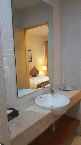 a bathroom with a sink and a mirror at PENINSULA SEMANTAN SUITEs in Kuala Lumpur