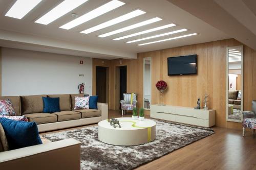 a living room with a couch and a tv at Mondim AL & Spa in Mondim de Basto