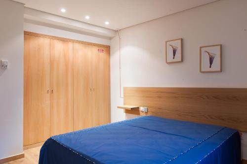 a bedroom with a blue bed and a wooden cabinet at Mondim AL & Spa in Mondim de Basto
