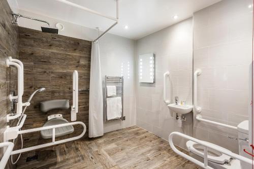 a bathroom with a toilet, sink, and bathtub at The Daffodil Hotel & Spa in Grasmere