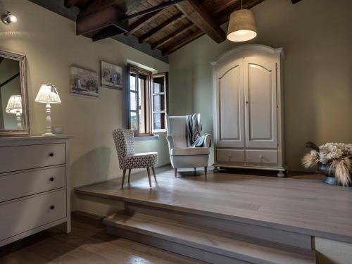 a living room with two chairs and a dresser at Agriturismo La Forra in Cavriglia