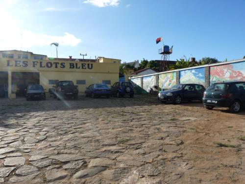 a parking lot with cars parked in front of a store at Hôtel - Appartement meublé " LES FLOTS BLEU " in Antananarivo