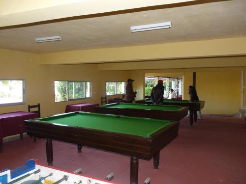 a room with two pool tables and purple chairs at Hôtel - Appartement meublé " LES FLOTS BLEU " in Antananarivo