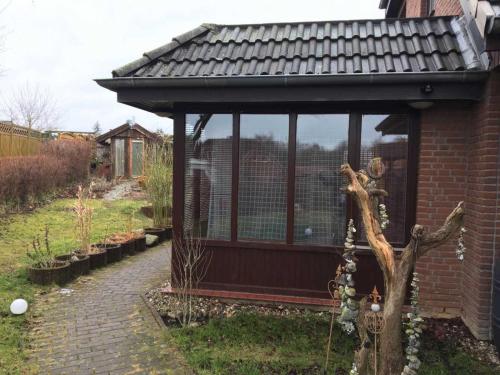 una gran jaula de aves en un jardín en Smans Fewo, en Neustadt in Holstein