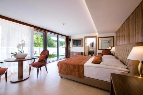 a bedroom with a bed and a table and chairs at Grand Hotel Donat Superior & Wellness Center in Rogaška Slatina