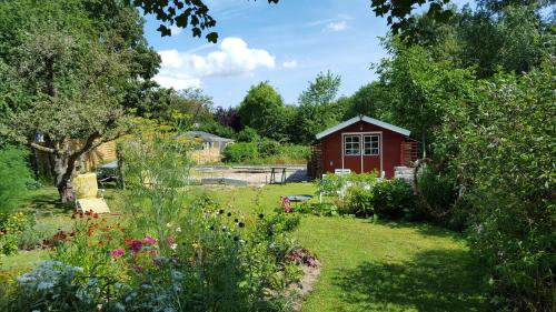 a garden with a red shed in the background at Vogler Lothar in Neustadt in Holstein