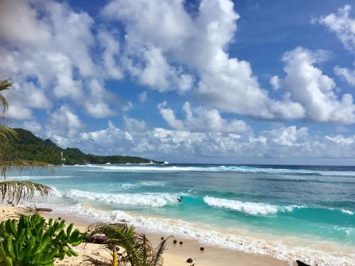 a beach with people swimming in the ocean at Bamboo Surf Beach in San Isidro