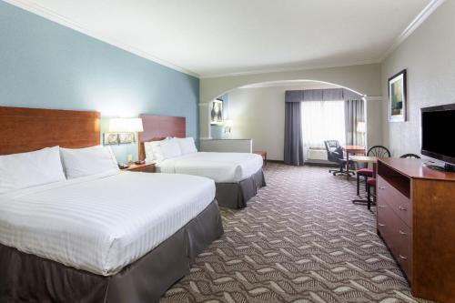 a hotel room with two beds and a television at Holiday Inn Express Hotel and Suites Lake Charles by IHG in Lake Charles