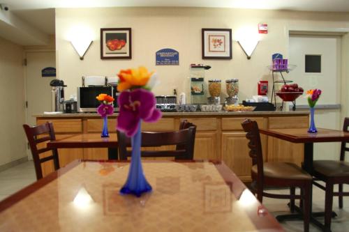 a table with three blue vases on top of it at Corona Hotel New York - LaGuardia Airport in Queens
