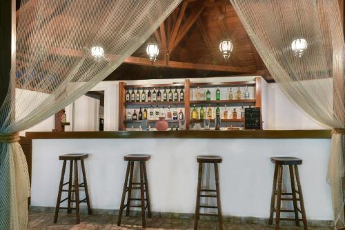 a bar with three bar stools in a room at Pyrgos Hotel in Ouranoupoli