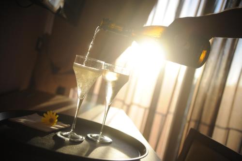 two champagne glasses sitting on a table with a lamp at Ostia Antica Suite B&B in Ostia Antica