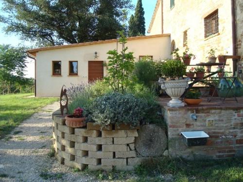 a house with a brick wall with plants in front of it at Al Giardino Degli Etruschi in Chiusi
