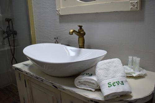 a bathroom with a white sink and towels on a counter at Vila Seva in Vatra Dornei