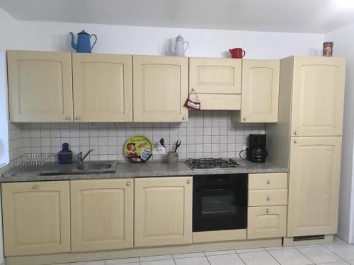 a kitchen with white cabinets and a stove top oven at le 2018 in Cancale