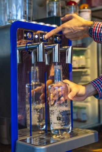 two people are holding a bottle in a machine at Hotel Arbe in Mutriku