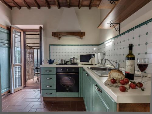 a kitchen with green cabinets and a sink and a stove at Agriturismo La Forra in Cavriglia