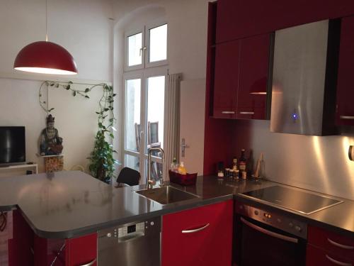 a kitchen with red cabinets and a counter top at Appartement am Tegeler See in Berlin