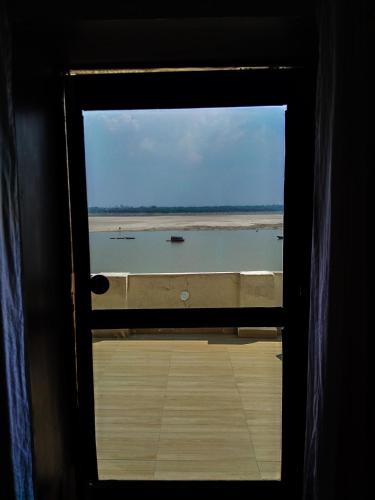a window view of the ocean from a boat at Dwivedi Hotels Sri Omkar Palace in Varanasi