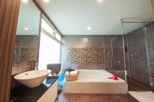 馬公市的住宿－海灣灣民宿，带浴缸、水槽和淋浴的浴室