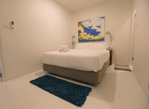 a bedroom with a bed with a painting on the wall at Hostel Lullaby Non-Smoking in Chiang Mai