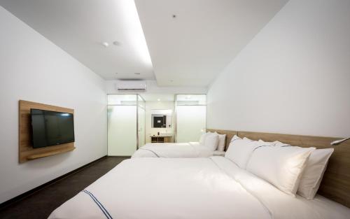a hotel room with a bed and a tv at Xianghe Hotel in Mingjian