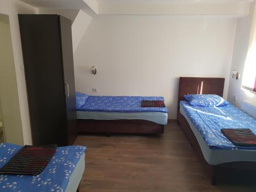 2 camas en una habitación con sábanas azules en Pension Haus Baron 2 Friedrichsfeld, en Edingen-Neckarhausen