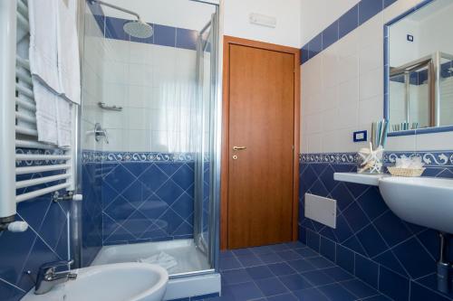 a blue bathroom with a shower and a sink at Angelina Residence in Maiori