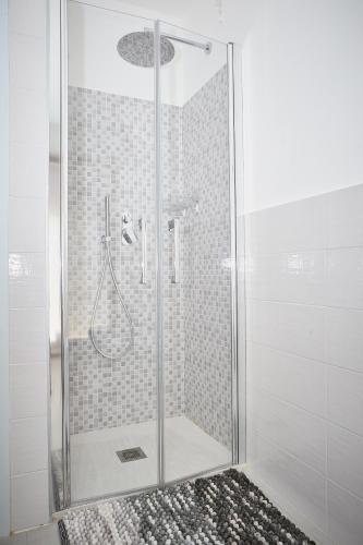 a shower stall with a glass door with a shower at Aerie Esmeralda in Como