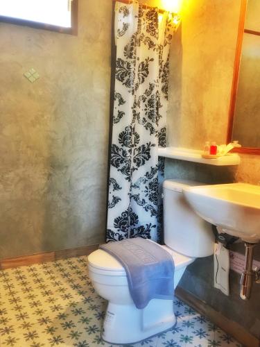 a bathroom with a toilet and a sink at Mango House in Sukhothai