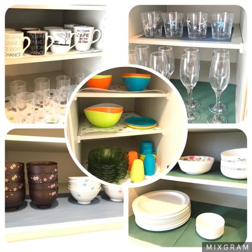 a cupboard filled with plates and bowls and dishes at ペンション アネラニハウス沖縄 in Onna