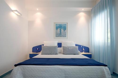 a bedroom with a blue and white bed with two pillows at Angelina Residence in Maiori
