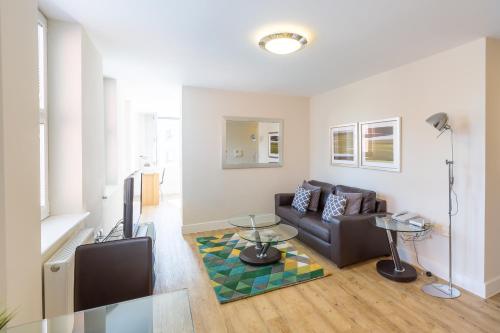 a living room with a couch and a table at House of Fisher - Central House in Camberley